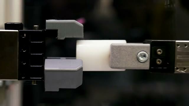 A precision gripper aligning a small component.