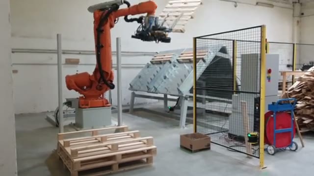 A robot stacking wooden pallets.