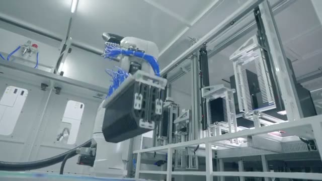 An industrial robot lifting and transferring a tray.